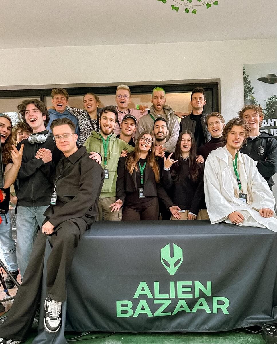 The Alien Bazaar organizers behind a table with the Alien Bazaar banner